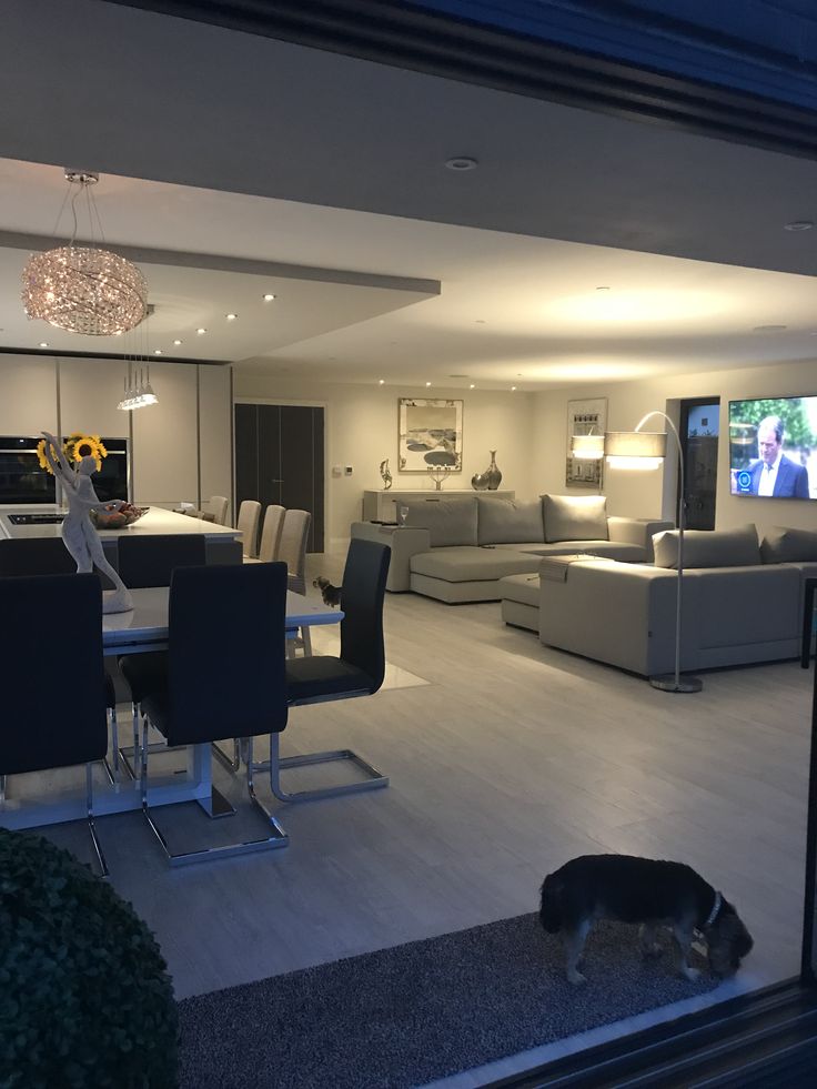 Elegant modern living room with cream curved sofas, geometric rug, and minimalist decor.